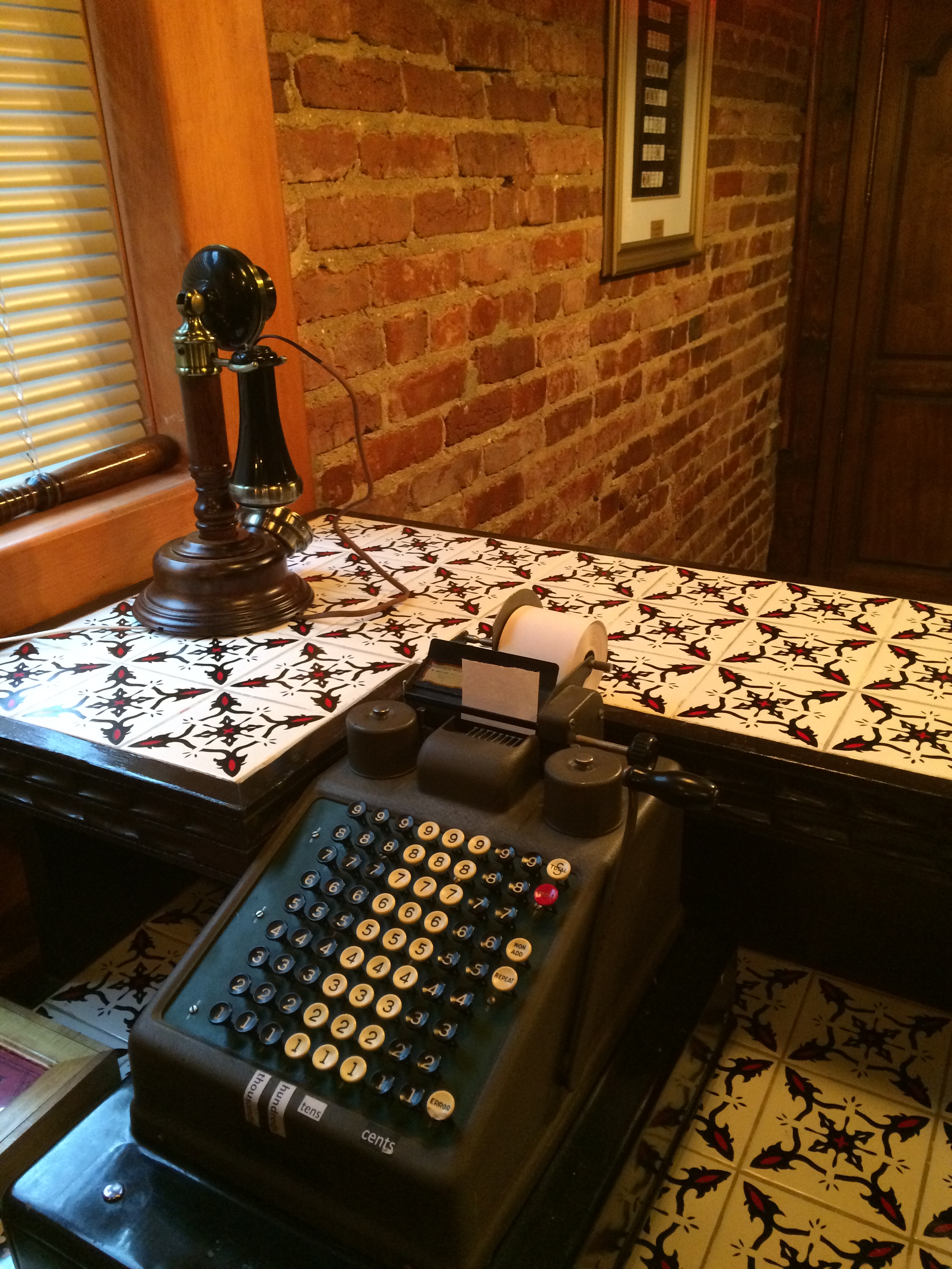 An old bar with a rotary phone, and a mechanical cash register.