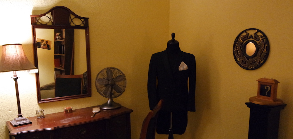 Interior of The Vanishing Act. Depicts a dressing room with a suit hanging elegantly.