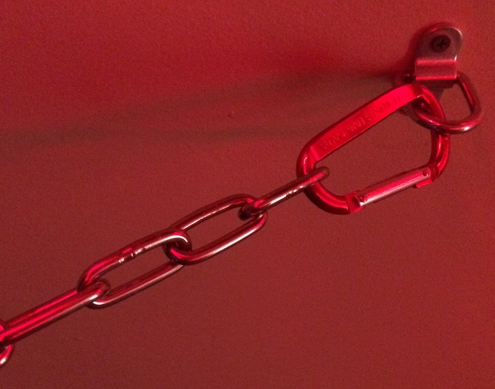A chain hooked to the wall via carabiner for quick release in emergency.