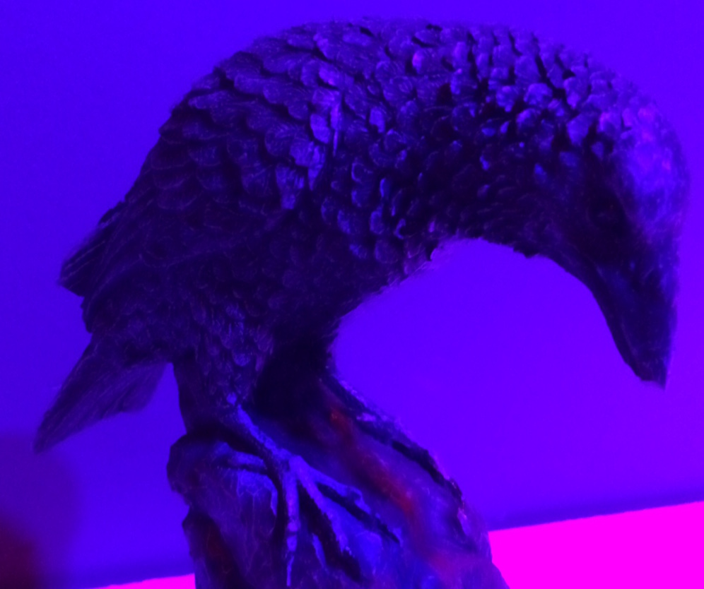 A statue of a raven, perched on a stone.