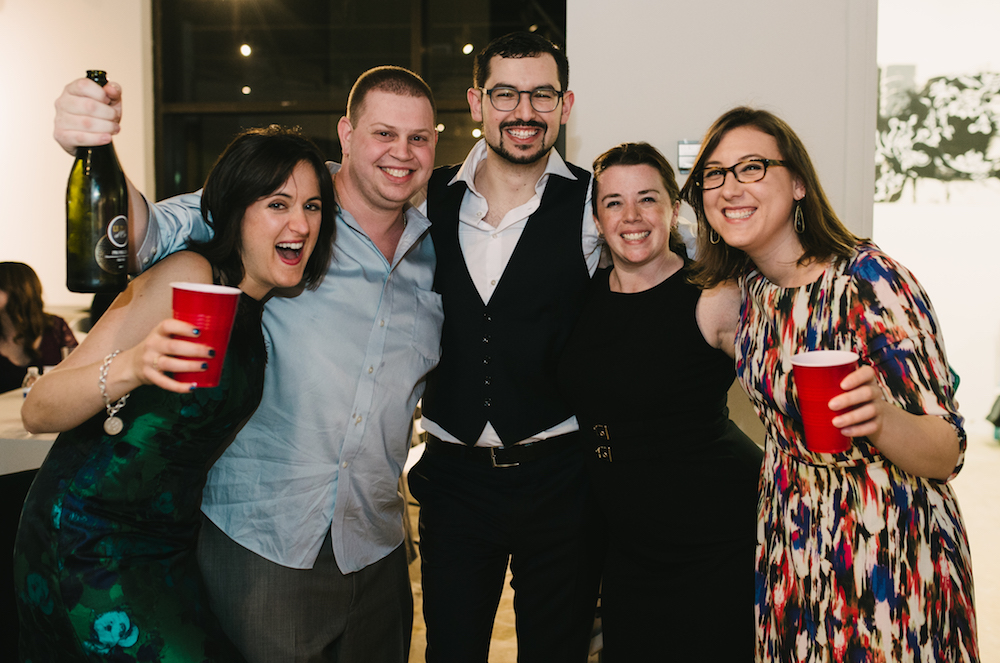Image of the successful team toasting David with bubbly.