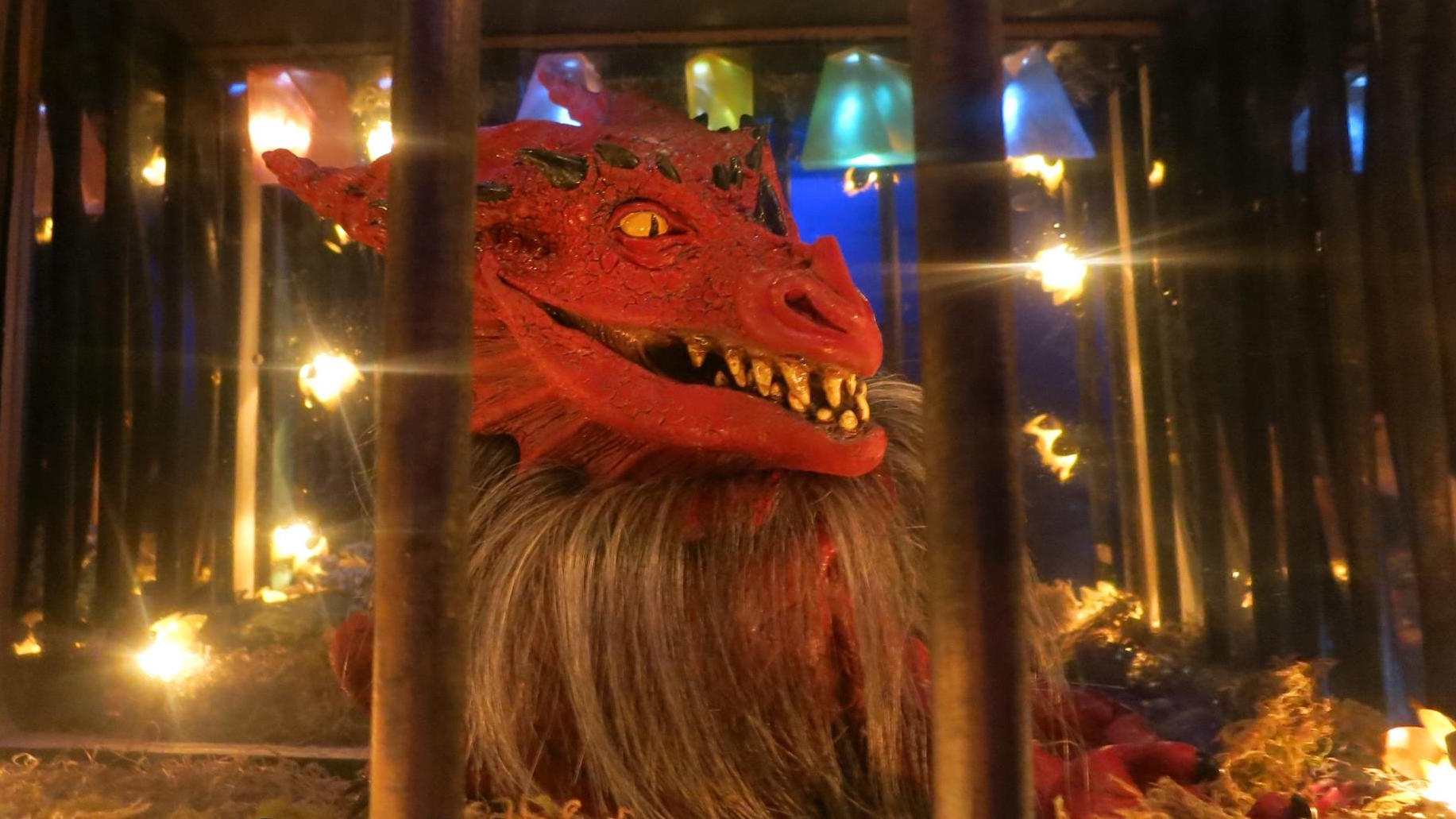 In-game image of a dragon locked behind bars.