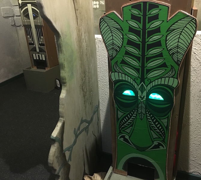 A tiki puzzle dispenser with green glowing eyes.