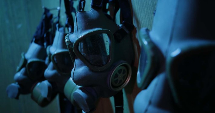 Close-up of a wall with gas masks hanging from it.