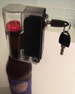 Tantalus Wine and Liquor Bottle Lock secured over a narrow mouthed bottle of beer.