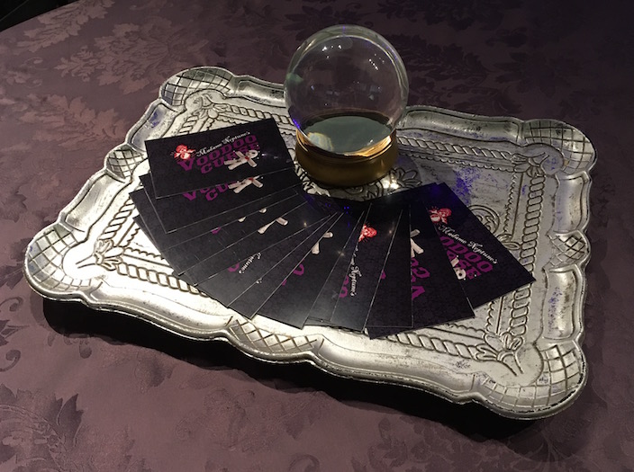 In-game: A metal platter with a crystal ball surrounded by Madame Neptune's Voodoo Curse cards.