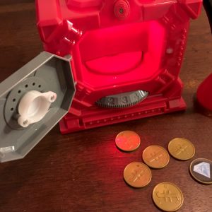 The safe popped open, a few coins are laying at its base.