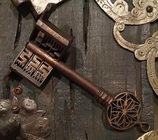 A complex warded key within a cutaway lock. It shows the key passing through the wards.