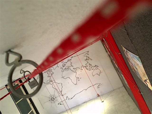 In-game: A rope chained a locked in a maze along the ceiling. A world map in the background. 