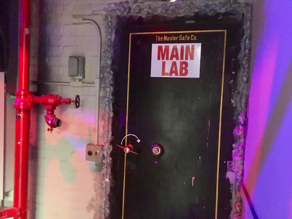 In-game: A large safe door labeled, "MAIN LAB."