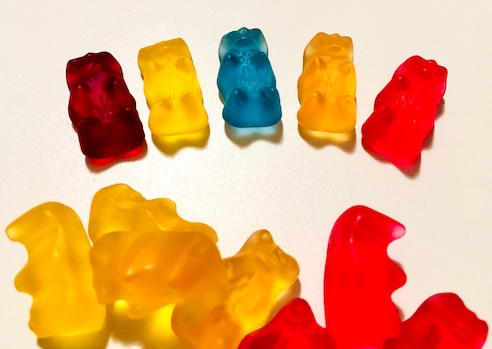The 5 colors of gummy bears laid out. The orange and yellow bears are very similar.