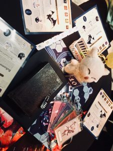 In-game: The initial table setup. There's a book sealed shut with a padlock, a Moogle doll, and an assortment of paper puzzle components.