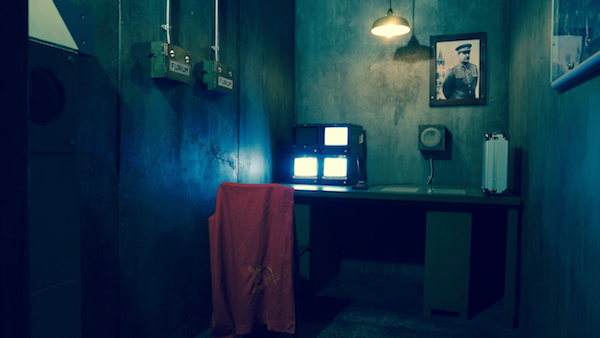 In-game: A concrete Soviet bunker with concrete walls, a PA system, and a photo of Stalin hanging on the wall. 