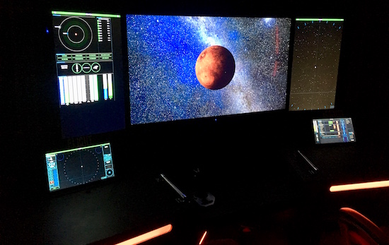 In-game: 5 of the ship's control screens. The main screen has a planet in view.