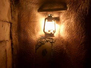 In-game: a lantern illuminating the stone walls of an Egyptian tomb.