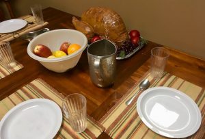 In-game: a set dining table with fruit and a turkey in the middle.