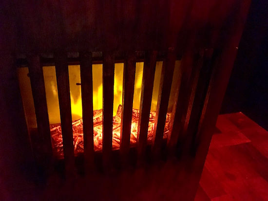 In-game: a burning furnace in a dark room.