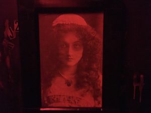 In-game: a hanging red and black portrait of a woman.