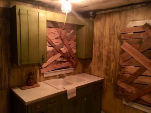 In-game: A rundown kitchen with boarded up windows.