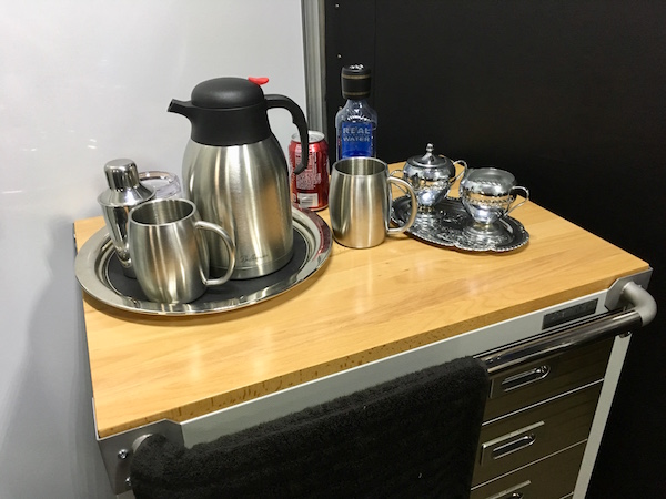 In-game: An airplane service cart with beverages and cups on top.