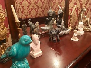 In-game: a shelf covered in statues of birds, elephants, mermaids, and other animals.