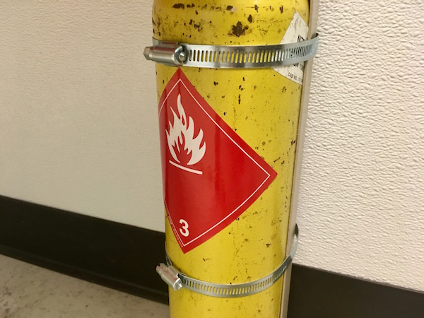 In-game: a yellow canister mounted to the wall with a flammable sticker on it.