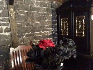 In-game: a black stone wall and armoire in the background.