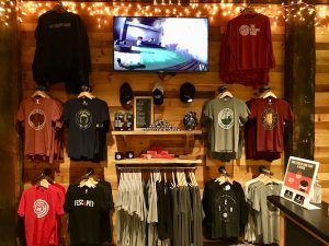 The Escape Game Nashville's merchandise area with a variety of t-shirts, hoodies, hats, and other products.