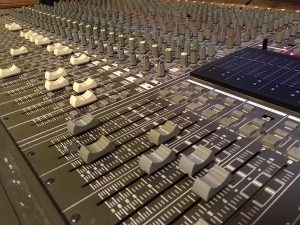 In-game: closeup of a large mixing board.