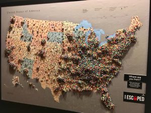 The visitor pushpin map from The Escape Game's lobby. It's covered in layers of pins and looks like a population density map of the USA.