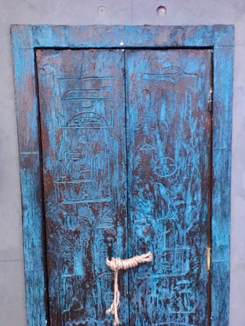 The blue and brown doorway to enter the game with Egyptian hieroglyphs carved into it.