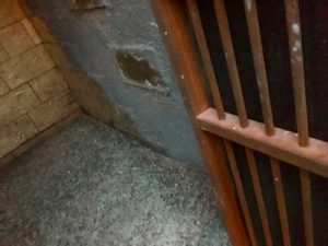 In-game: a barred metal door opening into a stone tomb.