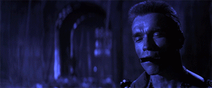 Schwarzenegger in The Last Action Hero smoking a cigar stating, "Not to be," and a bomb explodes behind him.
