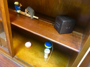 In-game: a cabinet of old wooden toys including a cup and ball and a yo-yo.