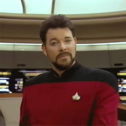 Commander Riker's blank expression slowing transforming into a an elated smile. 