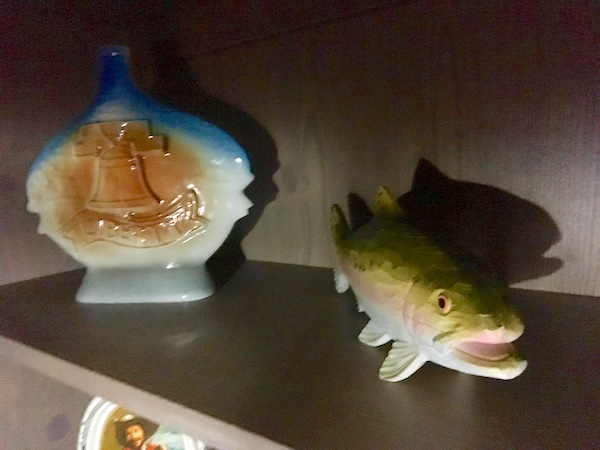 In-game: Ceramic bottles and a fish in a dim room.