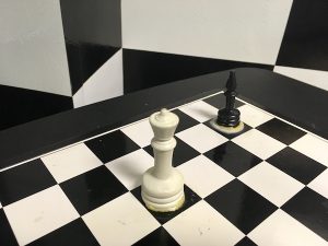 In-game: A chess set with a black bishop and white queen affixed to the board.