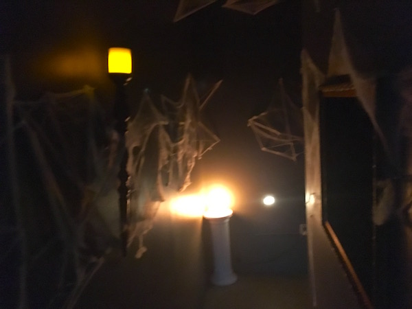 In-game: a long narrow hallway covered with cotton spider webs.