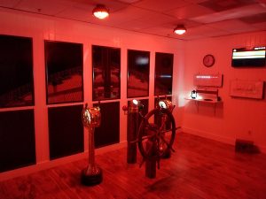 In-game: The helm of the ship with a large wheel.