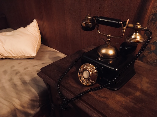 In-game: an old telephone beside a tossed bed.