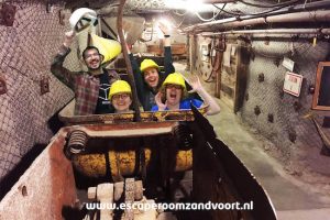 Post game green screen photo with the team riding a mining cart like it's a rollercoaster.