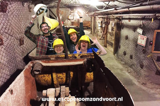 Post game green screen photo with the team riding a mining cart like it's a rollercoaster.