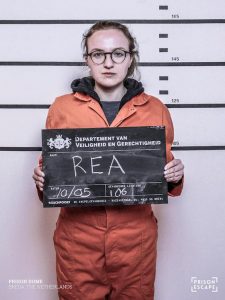 Lisa's Prison Escape mugshot in an orange jump suit.