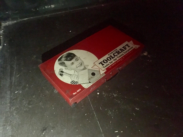 In-game: An old children's tool kit on a black floor.