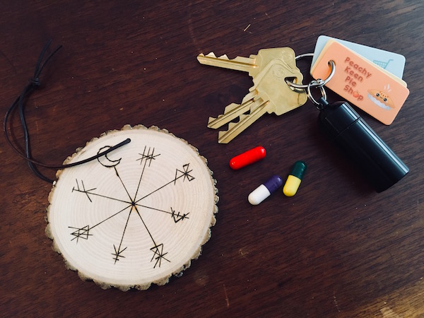 In-game: A keychain, a collection of pills, and an engraved wooden medallion.