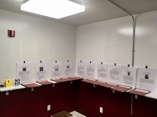 In-game: a large game corner covered in white board paint, case files, and goals for each case.