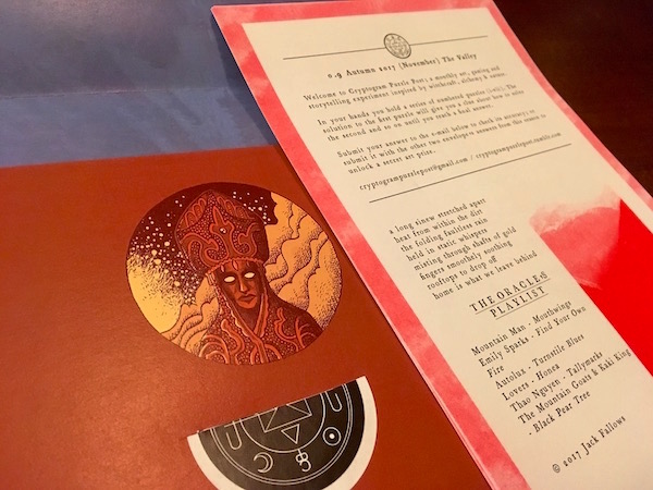 The first page of a Cryptogram Puzzle Post laying on an open envelope with a beautiful illustration. 