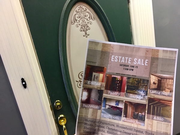 In-game: The front door of a home and a flier for an estate sale. 