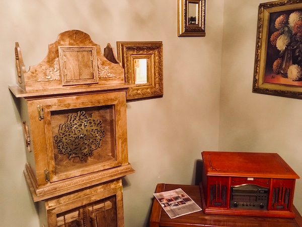 In-game: an old record player beside a strange and ornate wooden grandfather clock.
