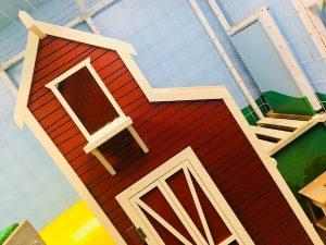 In-game: a bright and happy rat cage with a red barn-like structure.